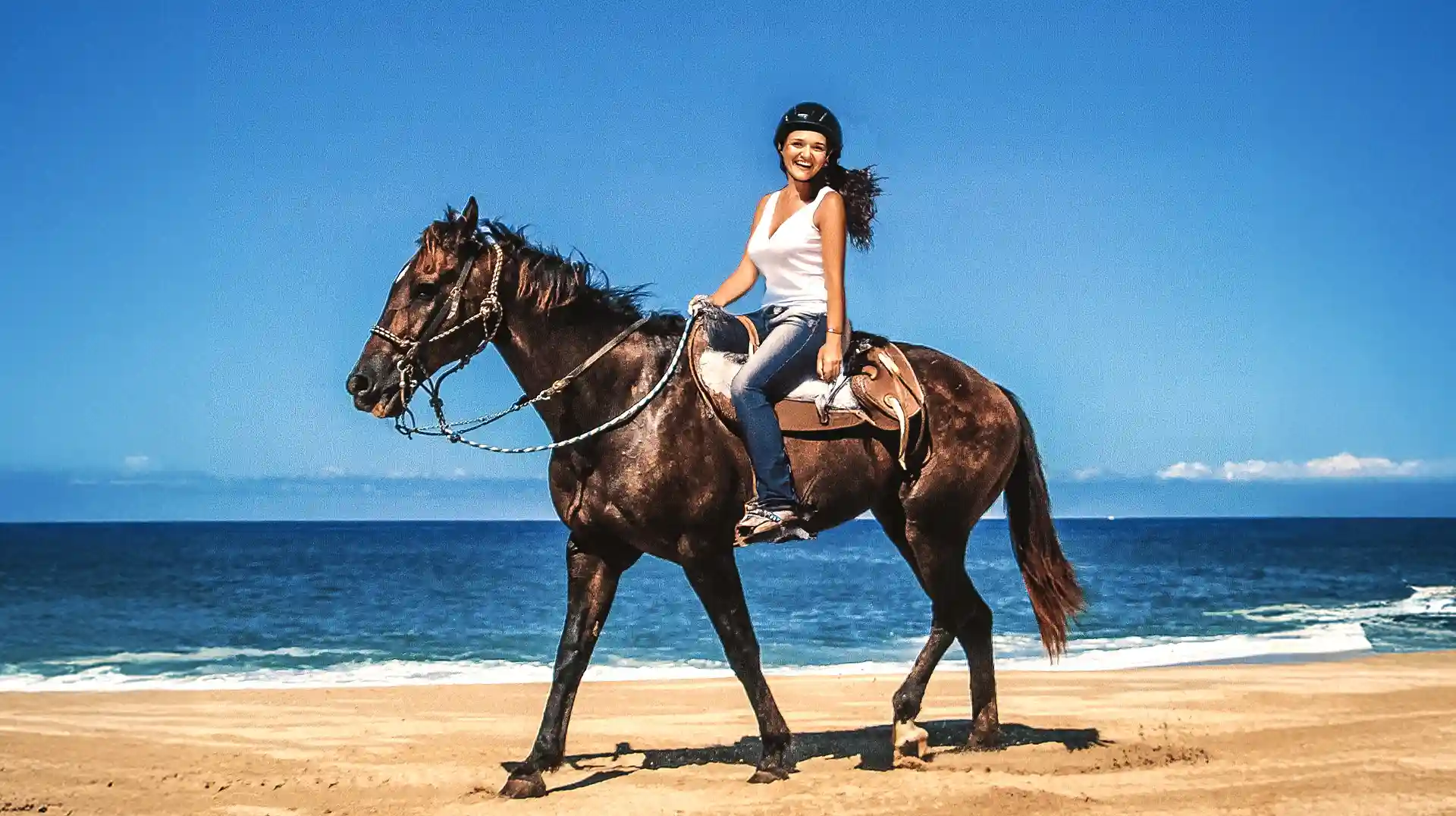 Mujer montando a caballo en la playa durante un tour en Los Cabos.