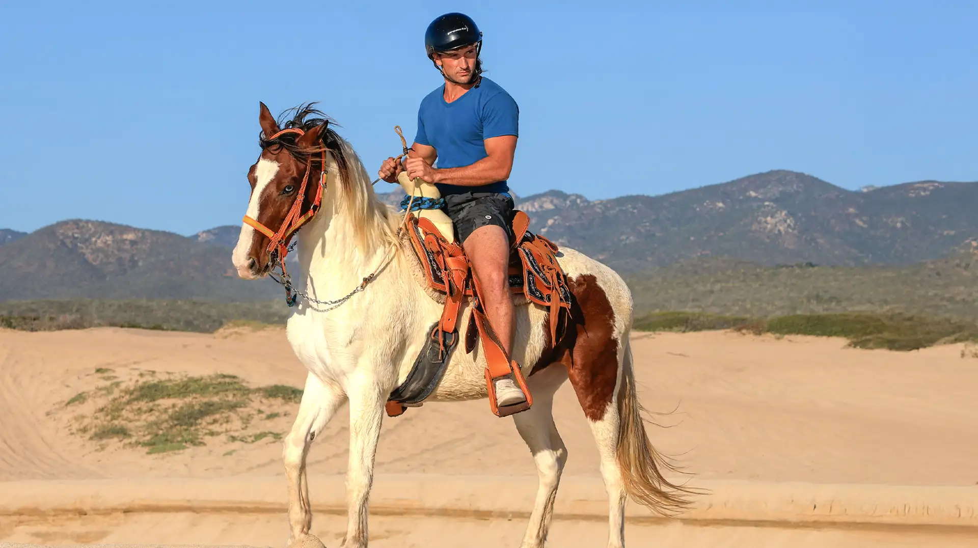 Hombre montando a caballo en el desierto de Los Cabos.