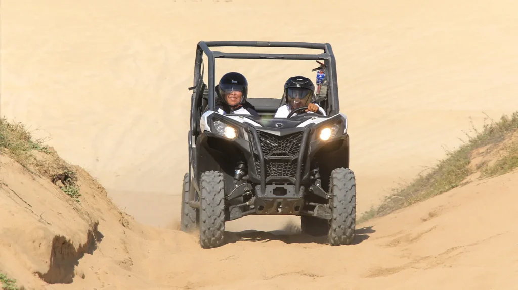 Pareja manejando un UTV Side by Side por senderos de arena en el desierto de Los Cabos