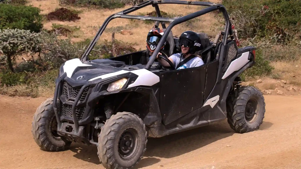 Pareja conduciendo un UTV Side by Side por camino de terracería en el desierto de Los Cabos