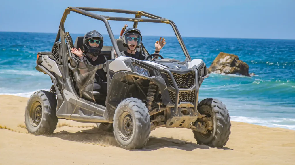 Dos personas conduciendo un UTV Side by Side junto al mar en Los Cabos