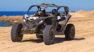 Pareja conduciendo Can-Am Maverick X3 en tour off road por la playa en Los Cabos