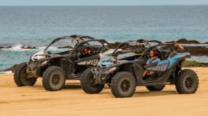 Dos Can-Am Maverick X3 conduciendo por la playa durante tour off road en Los Cabos